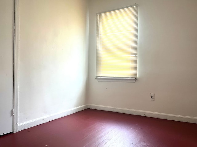 unfurnished room with dark hardwood / wood-style flooring and plenty of natural light