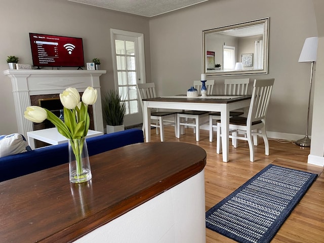 dining space featuring hardwood / wood-style flooring and a textured ceiling