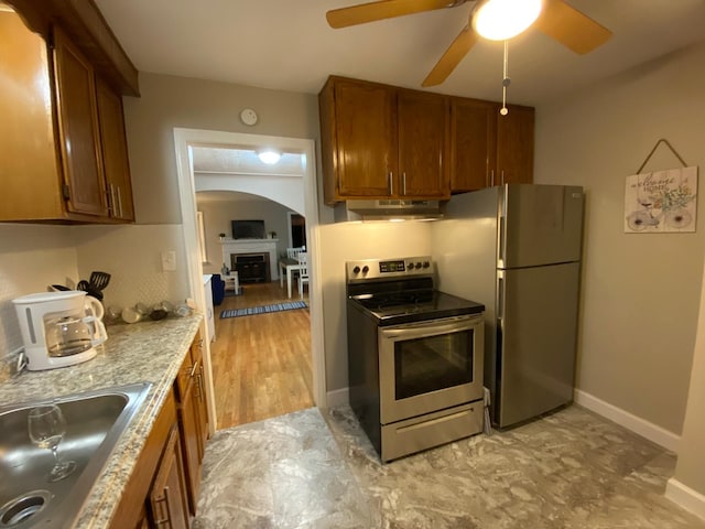 kitchen with ceiling fan, light wood-type flooring, sink, and appliances with stainless steel finishes