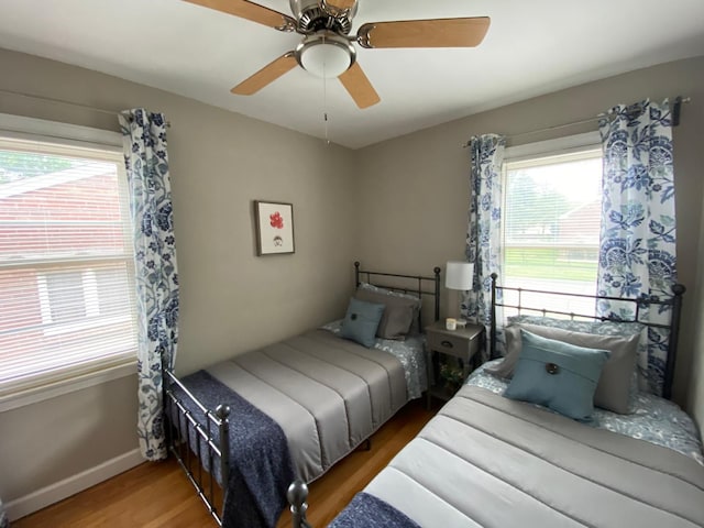 bedroom featuring multiple windows, ceiling fan, and wood-type flooring