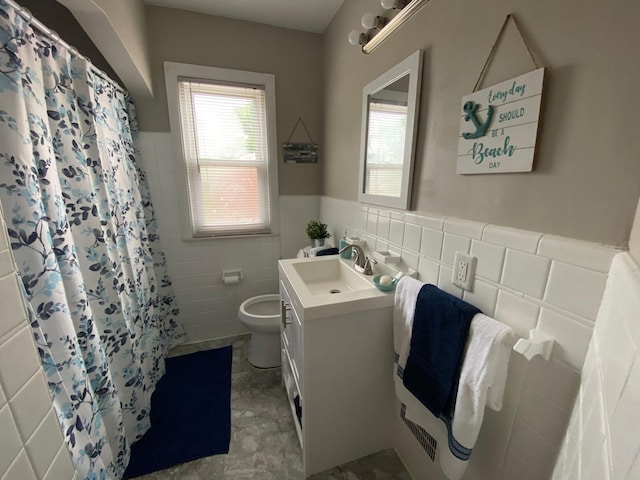 bathroom with vanity, toilet, tile walls, and walk in shower