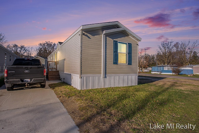 property exterior at dusk featuring a yard