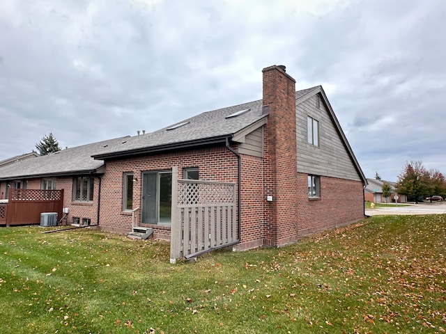 view of property exterior with central air condition unit and a lawn