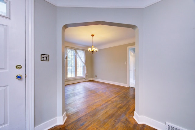 entrance foyer featuring a chandelier, dark hardwood / wood-style floors, and ornamental molding