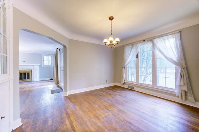 unfurnished room featuring an inviting chandelier and hardwood / wood-style flooring