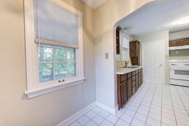 kitchen featuring light tile patterned flooring, sink, and electric stove