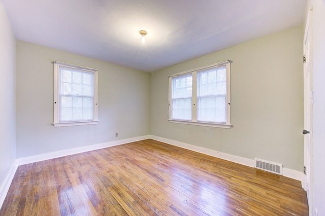 unfurnished room featuring hardwood / wood-style flooring and a healthy amount of sunlight