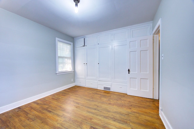 unfurnished bedroom featuring a closet and wood-type flooring