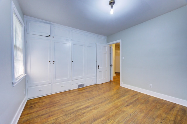 unfurnished bedroom featuring a closet and wood-type flooring