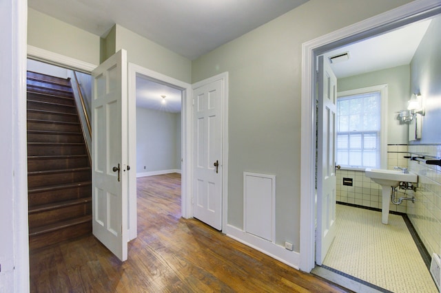 corridor with dark hardwood / wood-style flooring and tile walls