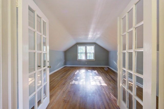 bonus room with dark wood-type flooring and vaulted ceiling