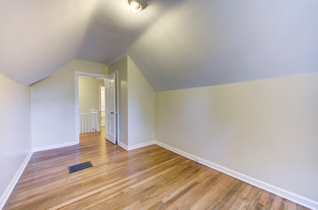 bonus room with light hardwood / wood-style floors and vaulted ceiling