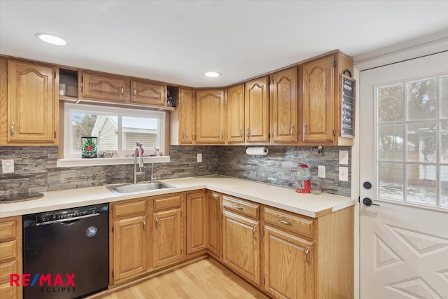 kitchen featuring decorative backsplash, black dishwasher, light hardwood / wood-style flooring, and sink