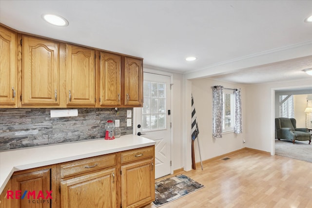 kitchen with light wood-type flooring and backsplash