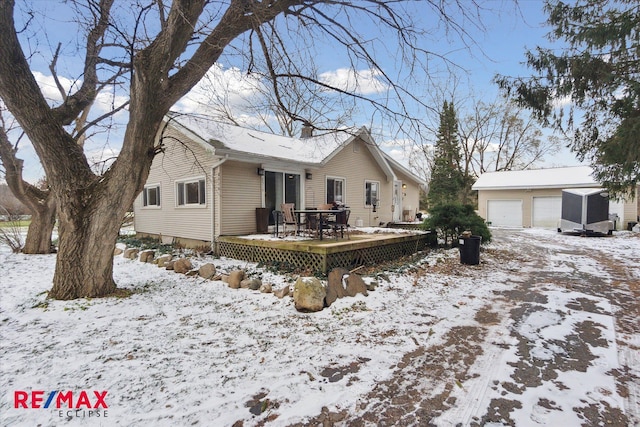 view of front of home featuring a wooden deck, an outdoor structure, and a garage