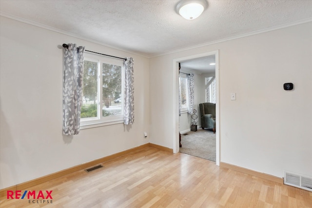 spare room featuring ornamental molding, a textured ceiling, and hardwood / wood-style flooring