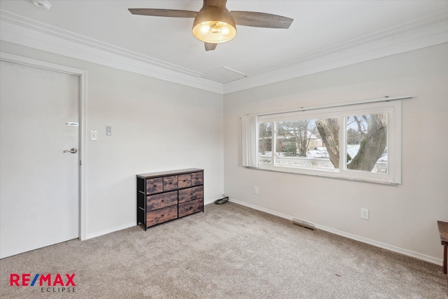 empty room with ceiling fan, light colored carpet, and ornamental molding