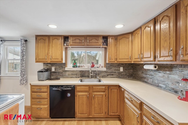 kitchen with decorative backsplash, light hardwood / wood-style floors, sink, and black dishwasher