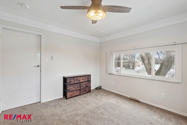 spare room featuring light carpet, ceiling fan, and ornamental molding