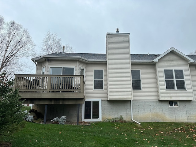 rear view of house featuring a lawn and a wooden deck