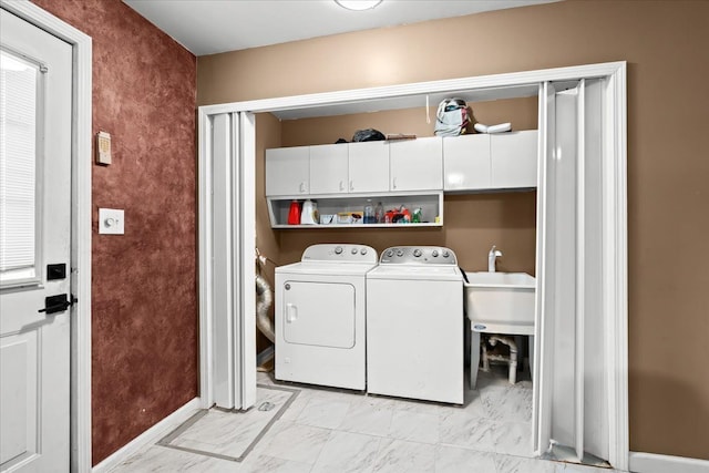 washroom with cabinets, sink, and washing machine and clothes dryer