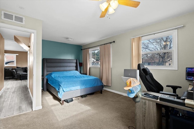 carpeted bedroom featuring multiple windows and ceiling fan