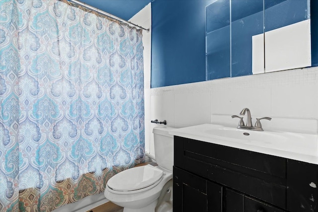 full bathroom featuring vanity, toilet, shower / bath combo with shower curtain, and tile walls