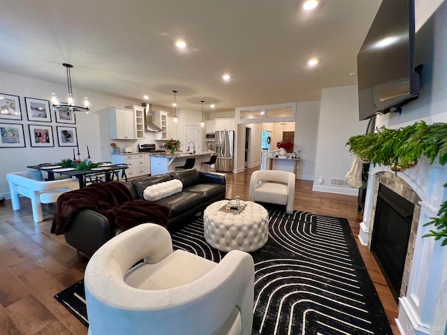 living room with sink, dark hardwood / wood-style flooring, and a notable chandelier