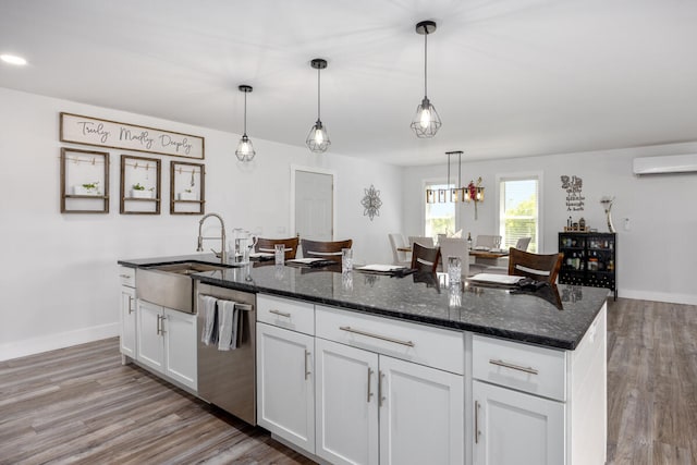 kitchen with white cabinetry, pendant lighting, dark stone counters, and dishwasher