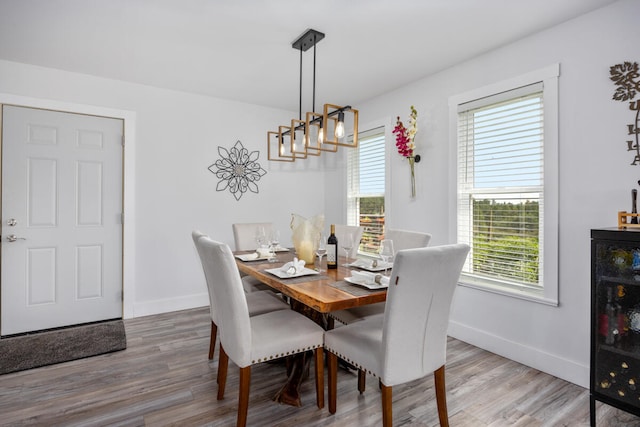 dining space featuring wine cooler, hardwood / wood-style flooring, a chandelier, and a healthy amount of sunlight