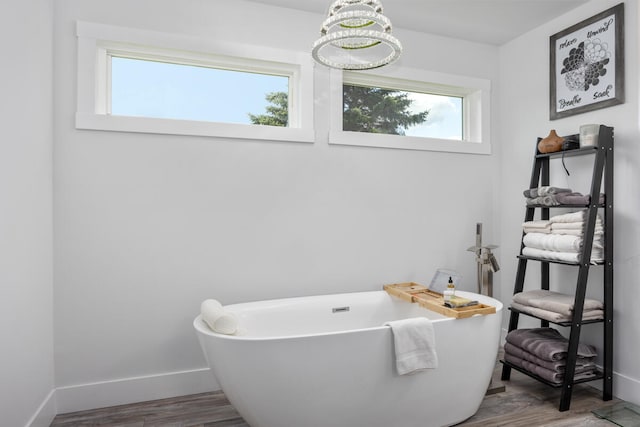 bathroom with a bath, hardwood / wood-style floors, and a wealth of natural light