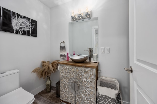 bathroom with wood-type flooring, toilet, and vanity