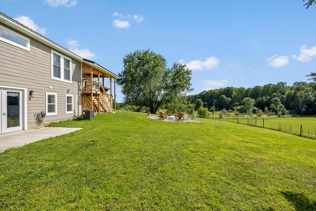 view of yard with a patio, a wooden deck, central AC unit, and an outdoor fire pit