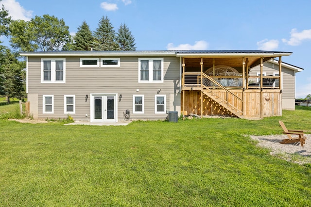 back of property with french doors, a yard, a deck, and central AC