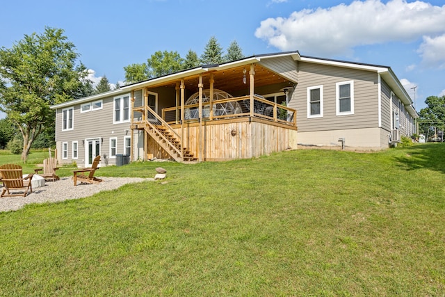 back of property featuring a wooden deck, a lawn, and an outdoor fire pit