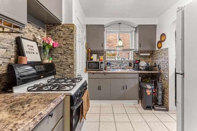 kitchen with gray cabinets, white range with gas stovetop, sink, and tasteful backsplash