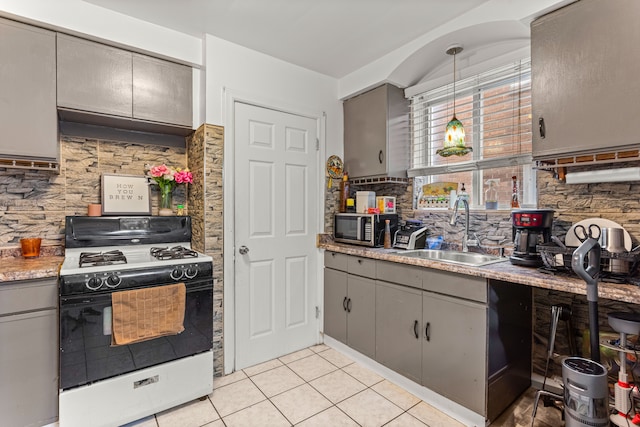 kitchen featuring gray cabinetry, gas range gas stove, sink, hanging light fixtures, and exhaust hood