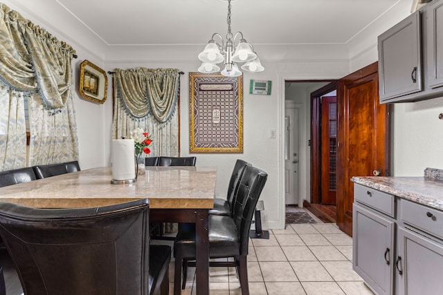 tiled dining space with an inviting chandelier and crown molding