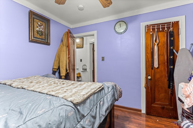 bedroom with ceiling fan, crown molding, dark wood-type flooring, and a closet