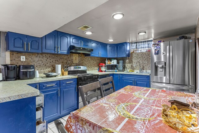 kitchen featuring decorative backsplash, appliances with stainless steel finishes, blue cabinets, sink, and light tile patterned floors