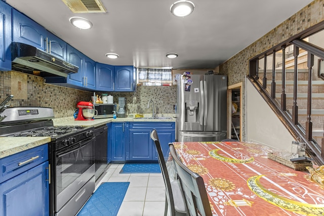 kitchen with blue cabinetry, sink, light tile patterned floors, and appliances with stainless steel finishes