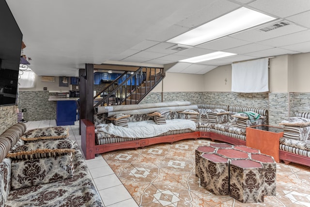 tiled living room featuring a paneled ceiling