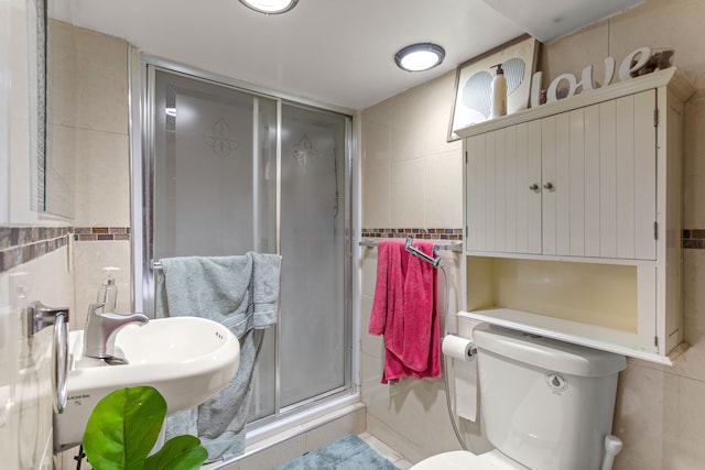 bathroom featuring toilet, an enclosed shower, and tile walls