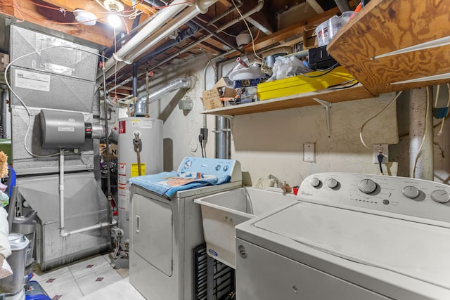 clothes washing area with sink, gas water heater, and independent washer and dryer