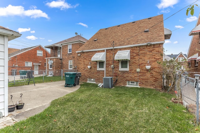 rear view of property featuring a yard and central AC