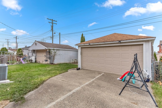 garage with central air condition unit and a lawn