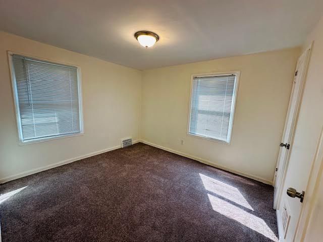 empty room featuring dark carpet