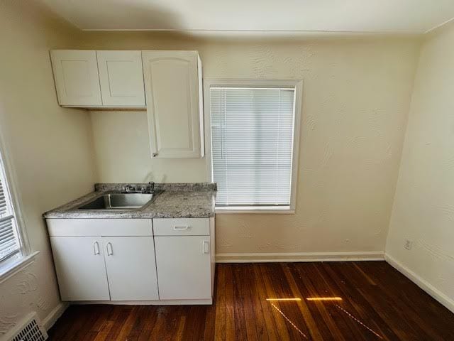 kitchen with white cabinets, a healthy amount of sunlight, and dark wood-type flooring