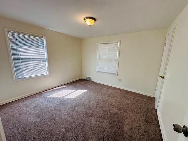 empty room with dark colored carpet