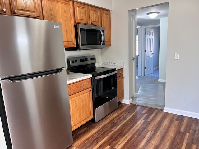 kitchen with appliances with stainless steel finishes and dark hardwood / wood-style flooring